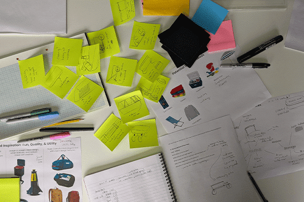 Brand Development brainstorm with green post-it notes and paper