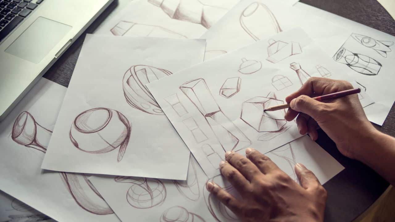 Someones hands drawing product designs in the product development stage